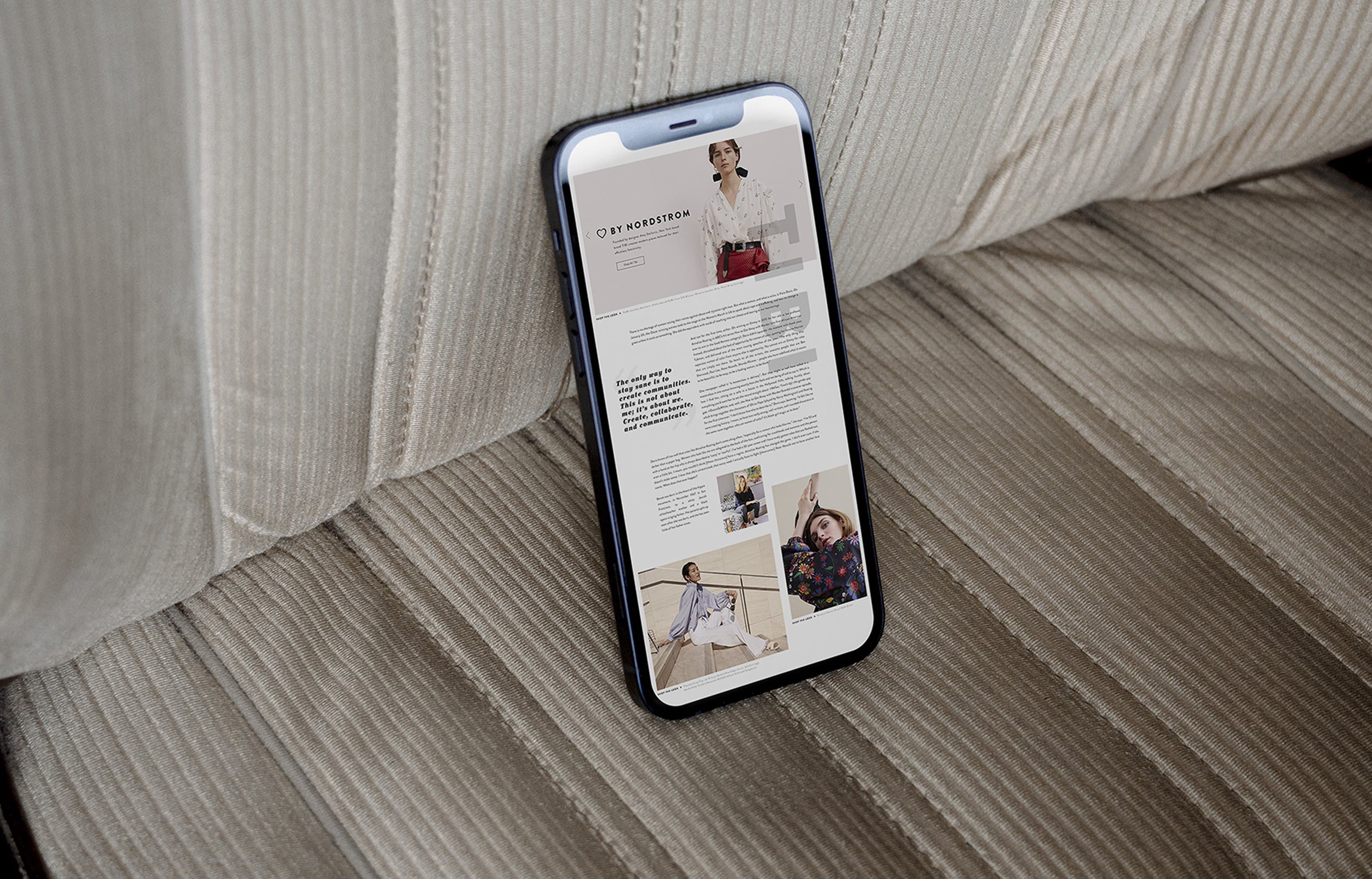 iPhone showing By Nordstrom landing page laid on corduroy couch