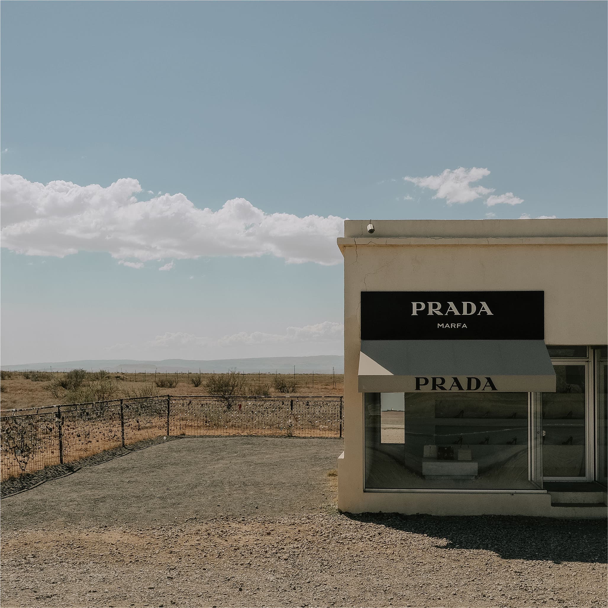 The Prada Marfa storefront up close, its windows displaying shoes in the desert light