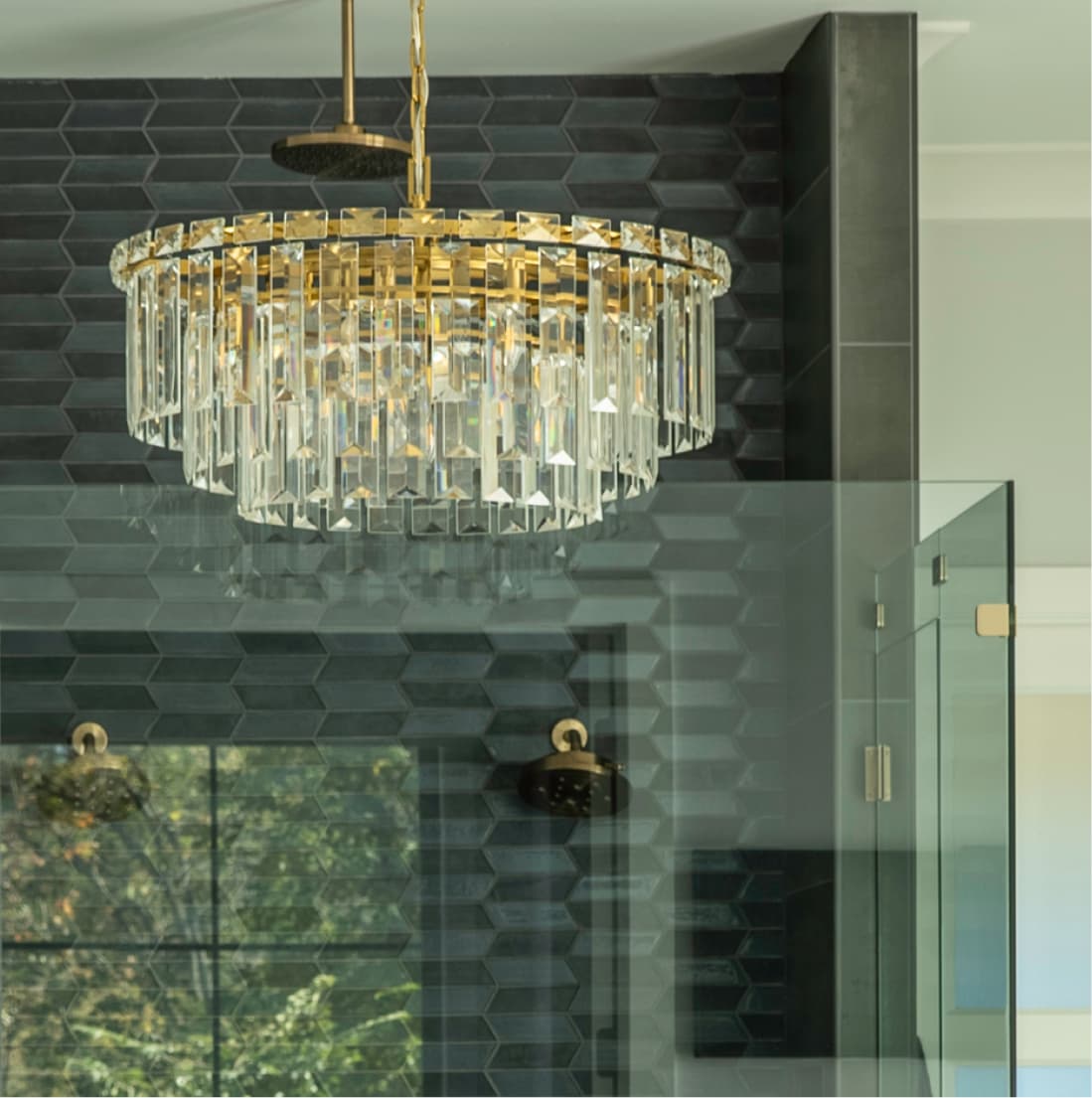 Crystal chandelier suspended above charcoal hexagon tile in ensuite