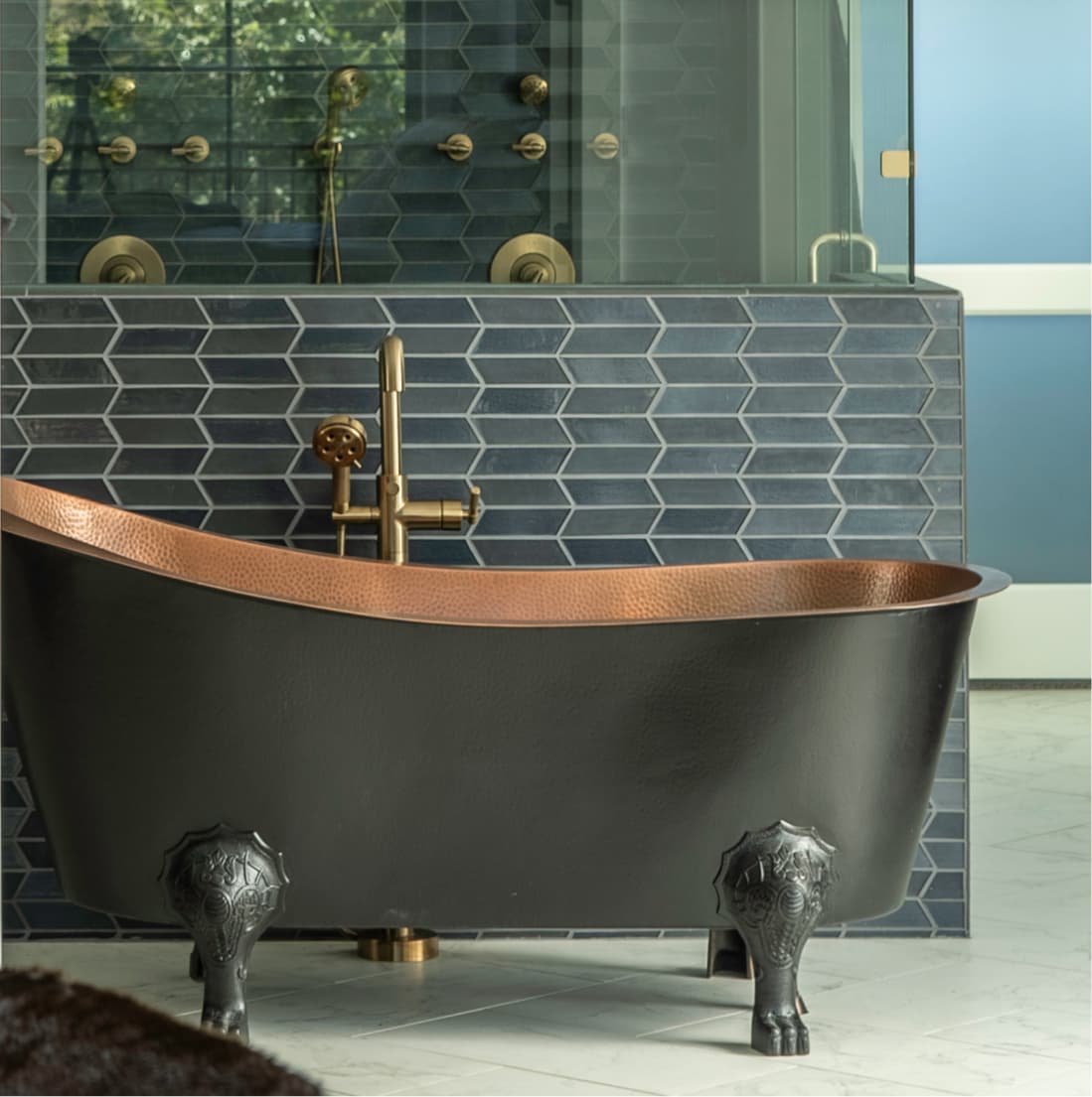 Hammered copper clawfoot tub with brass faucet, charcoal hex tile backdrop