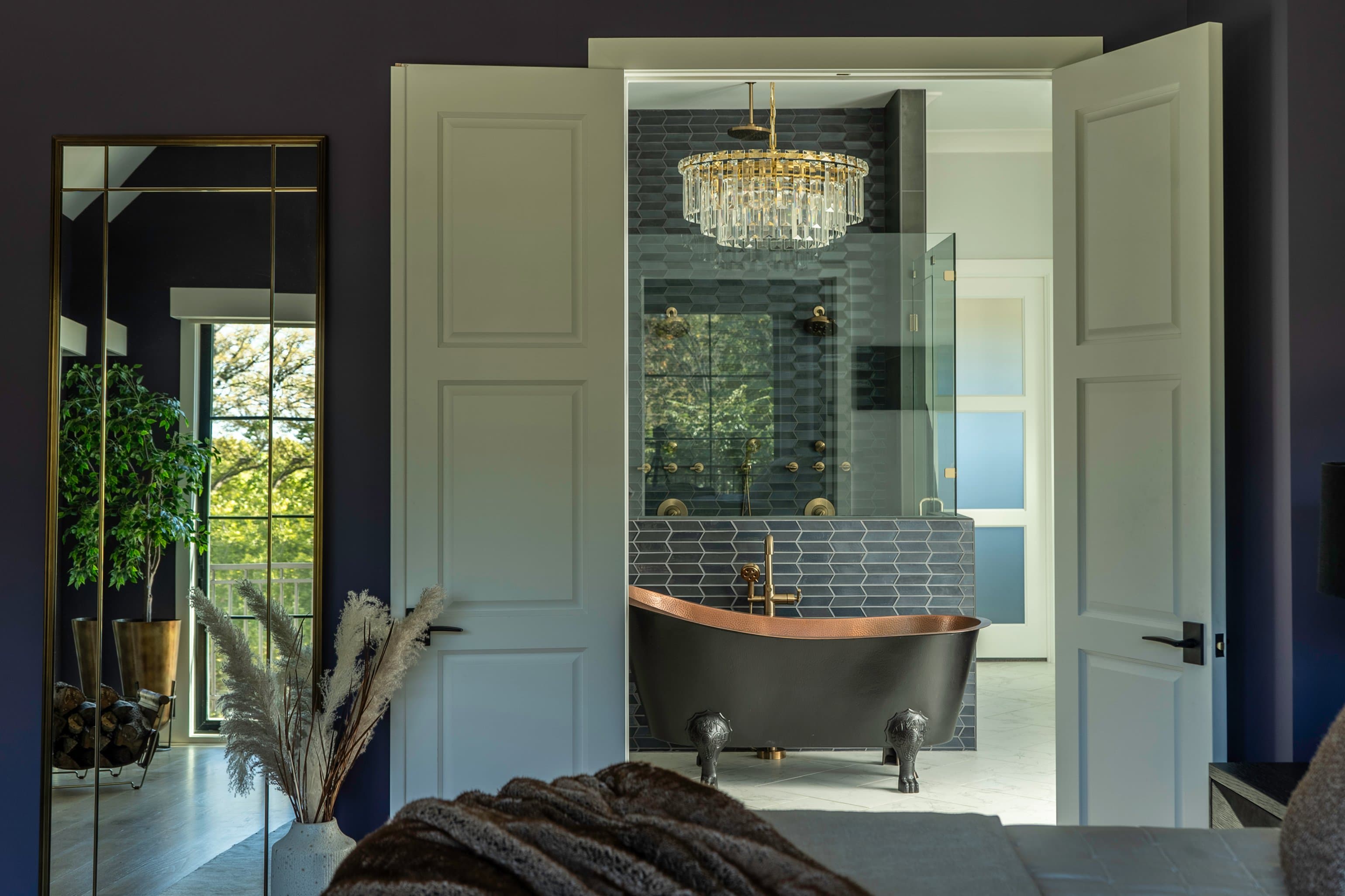 View through double doors to ensuite, copper clawfoot tub, crystal chandelier, charcoal hex tile