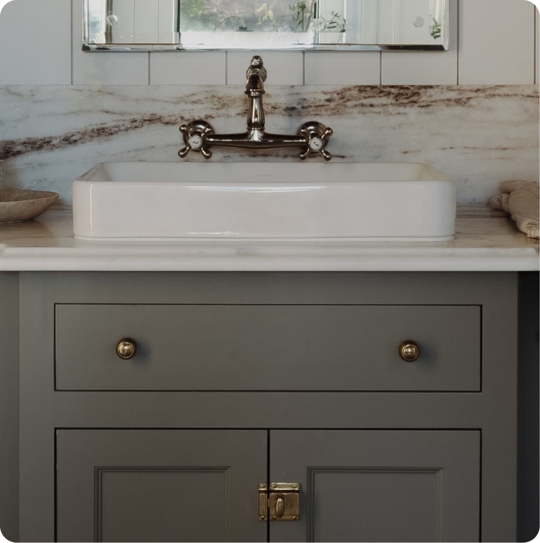 Vanity detail, vessel sink with bridge faucet, dramatically veined marble slab