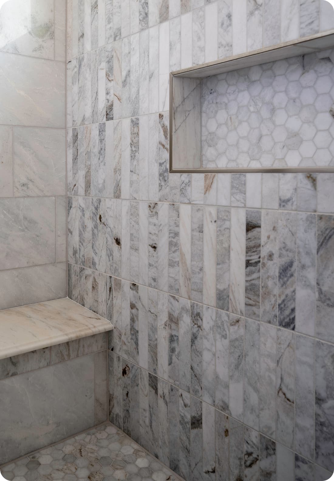Marble shower, recessed niche with hex tile, bench, mixed vertical and horizontal marble