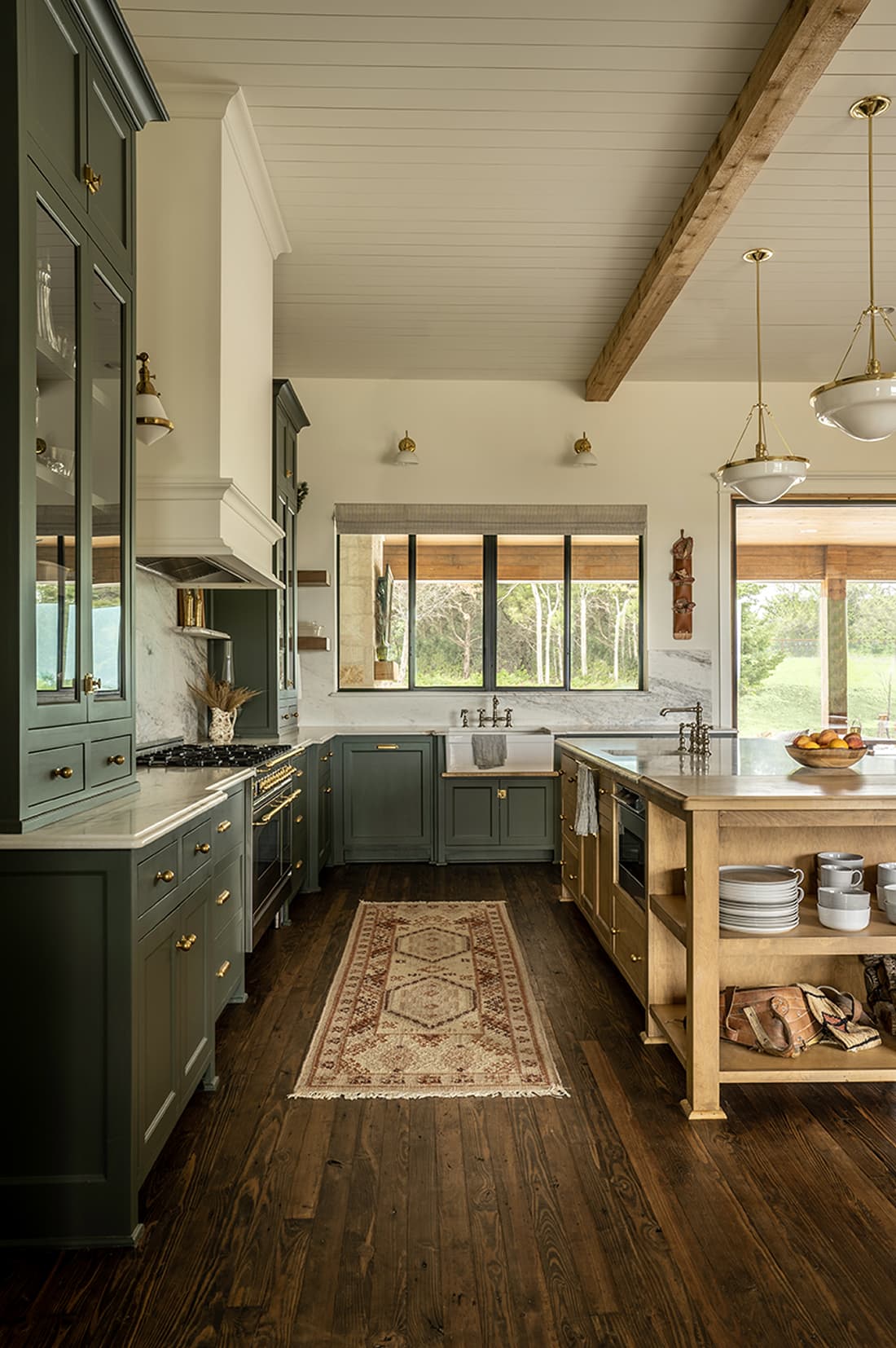 Full kitchen view with exposed beams, runner rug, white oak island