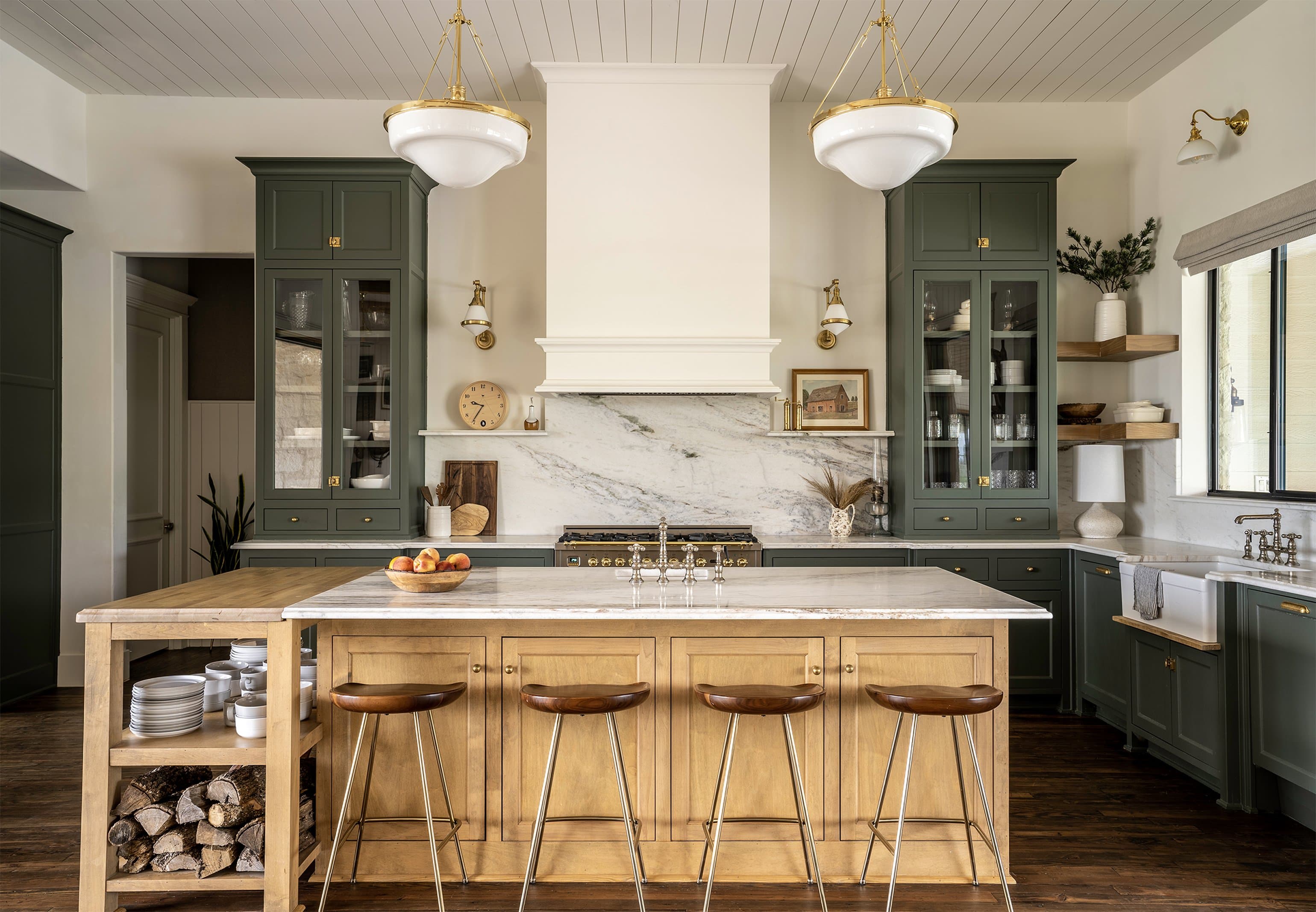 Hill Country kitchen, sage green cabinetry with marble backsplash, white oak island, brass pendants