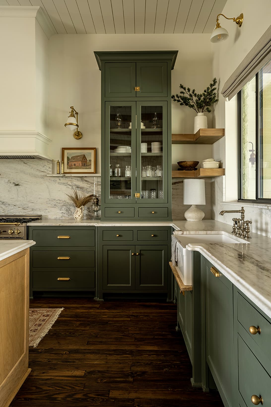 Sink corner with open shelving, marble backsplash, brass faucet