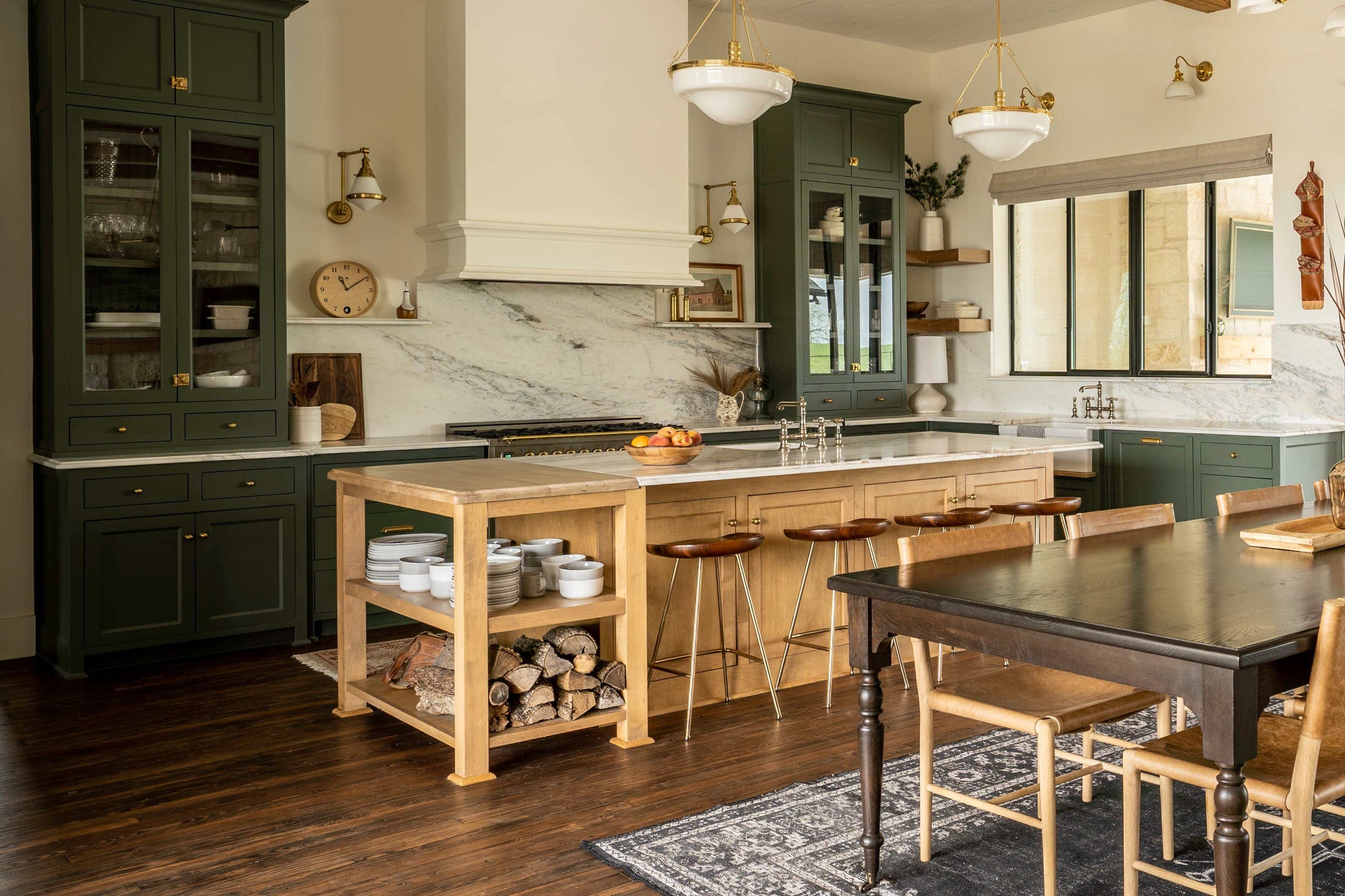 Full kitchen view with dining table, island, sage green cabinetry, steel-frame windows