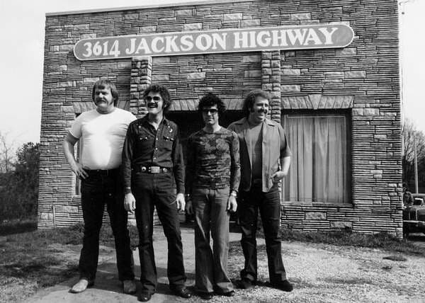 Black-and-white photo, four musicians outside the 3614 Jackson Highway studio