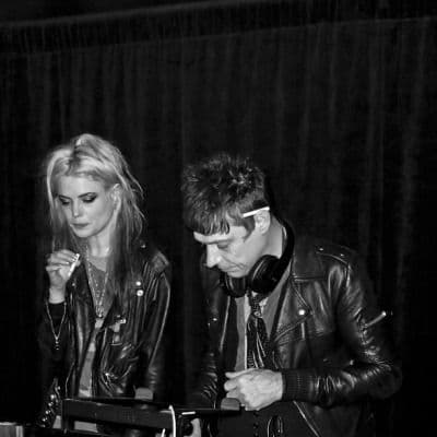 Black-and-white live shot, two band members at keyboards in leather jackets