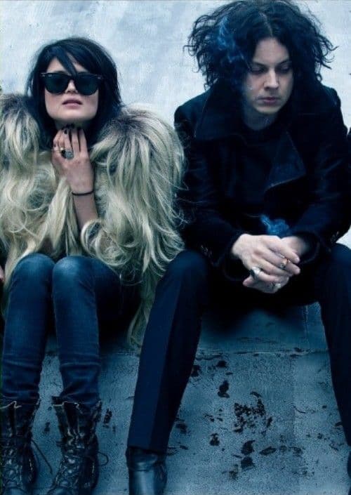 Black-and-white portrait of Allison Mosshart and Jack White seated on concrete