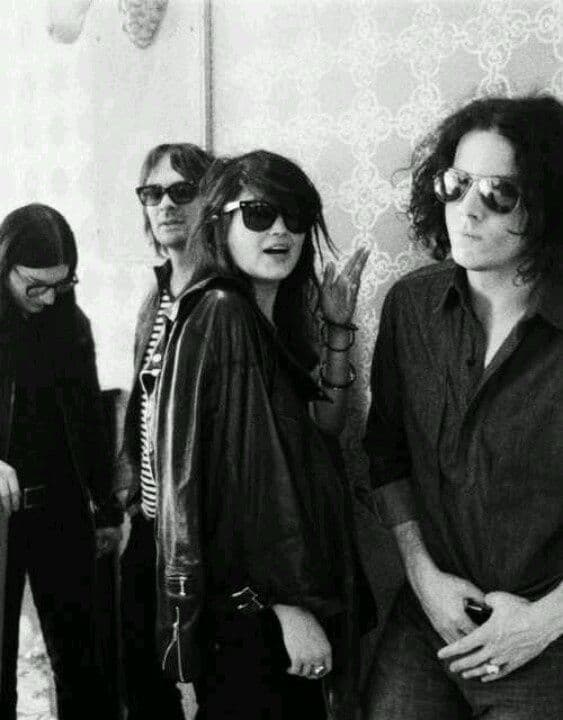 Black-and-white band portrait, four musicians against patterned wallpaper