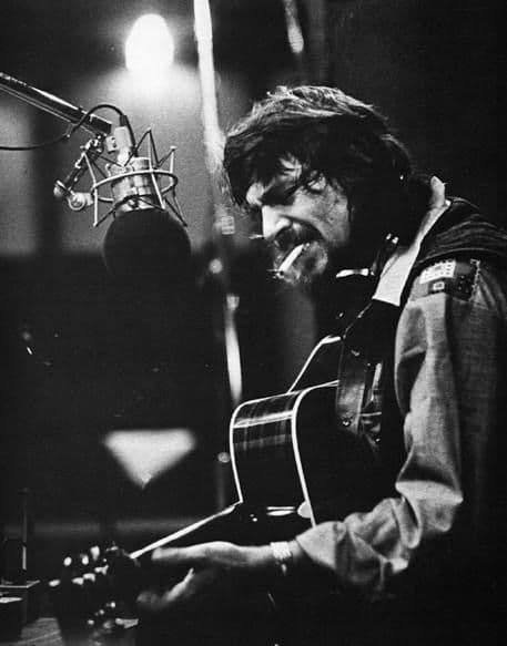 Black-and-white musician at studio microphone with acoustic guitar