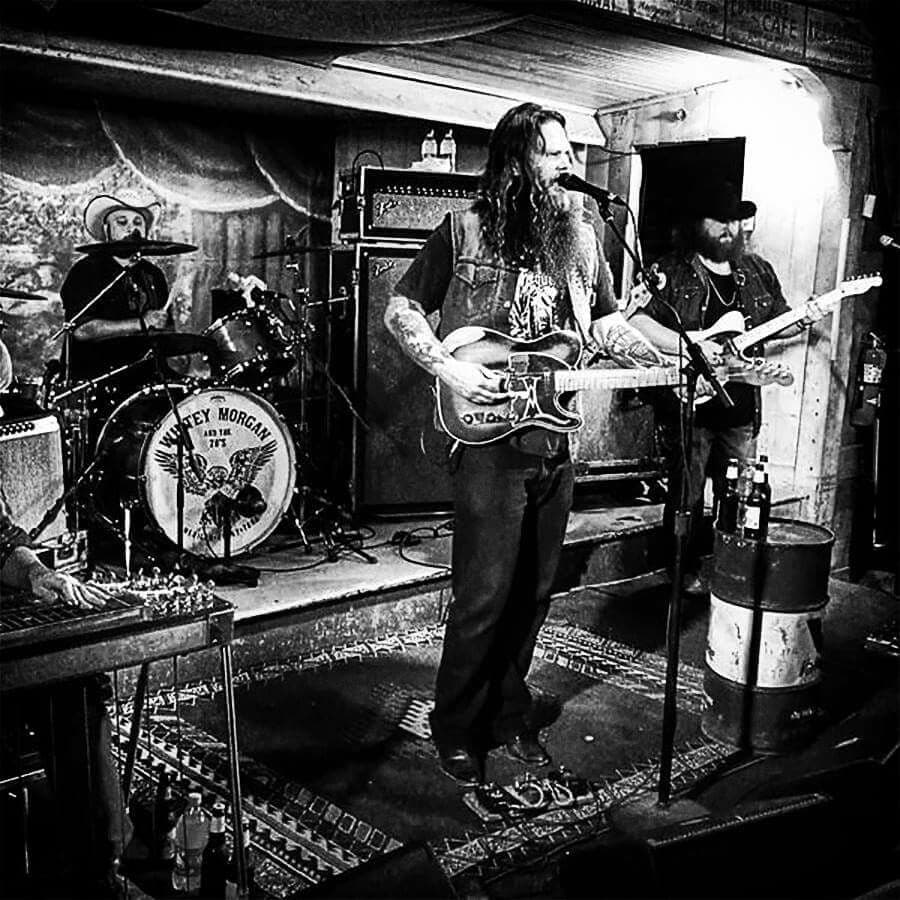 Black-and-white live shot of country band on a small honky-tonk stage