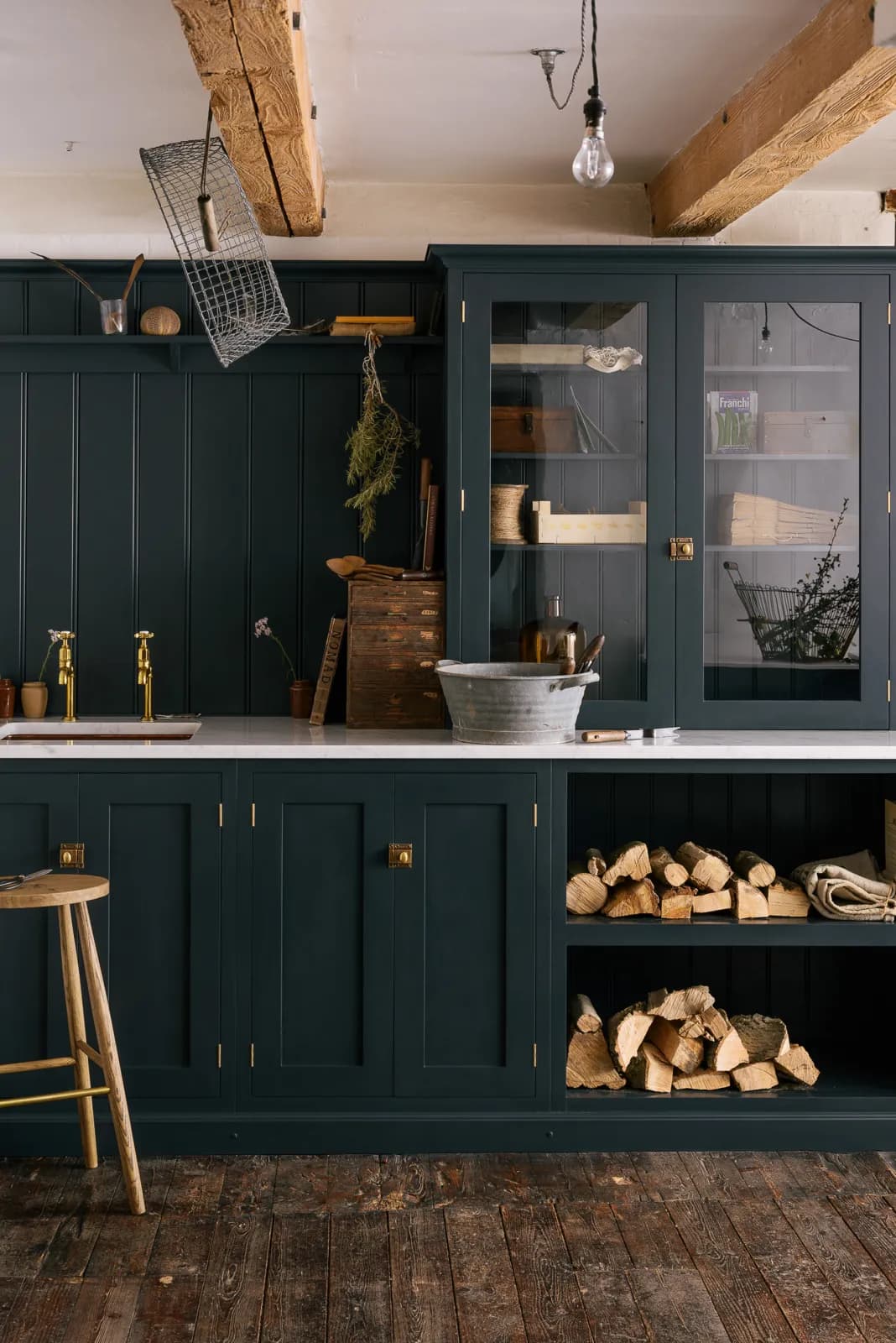 DeVol Shaker kitchen with dark blue painted cabinetry and stacked firewood