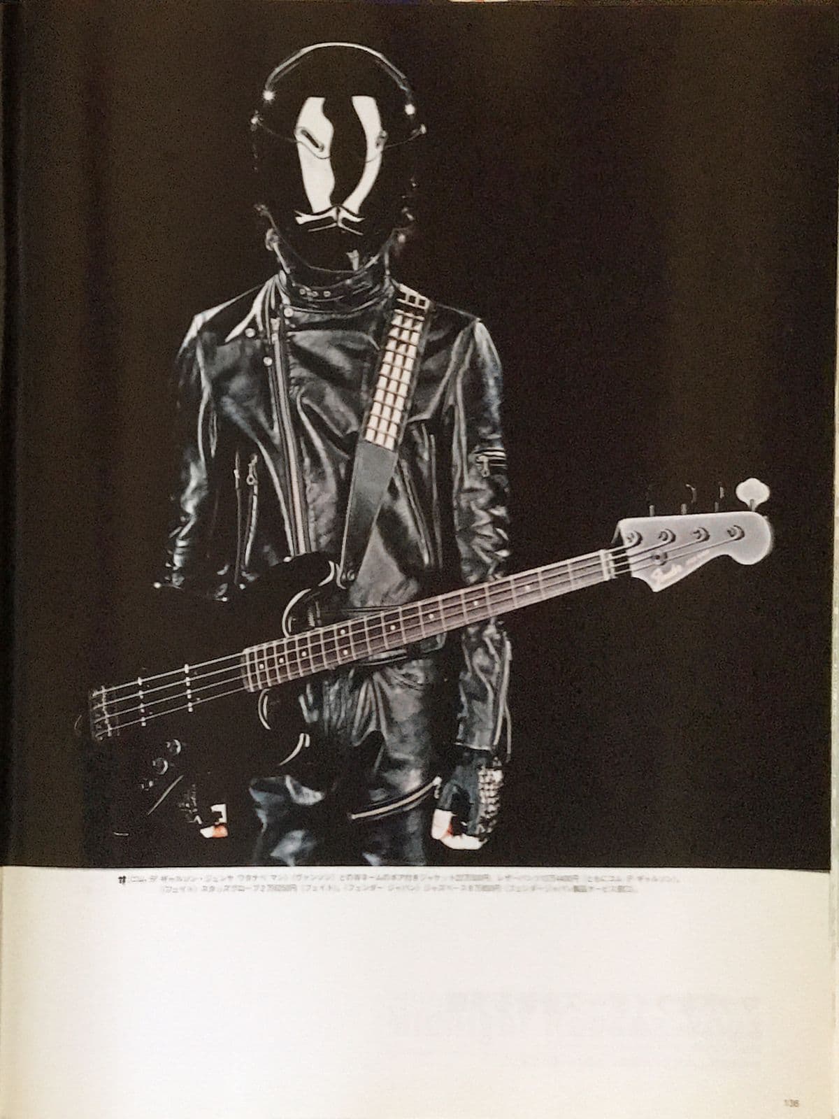 Editorial portrait, figure in motorcycle helmet and leather jacket with a bass guitar