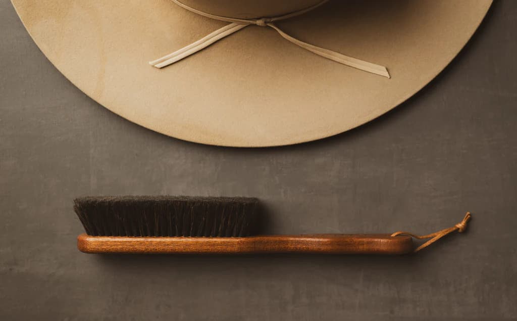 Camel felt cowboy hat with horsehair brush flat lay
