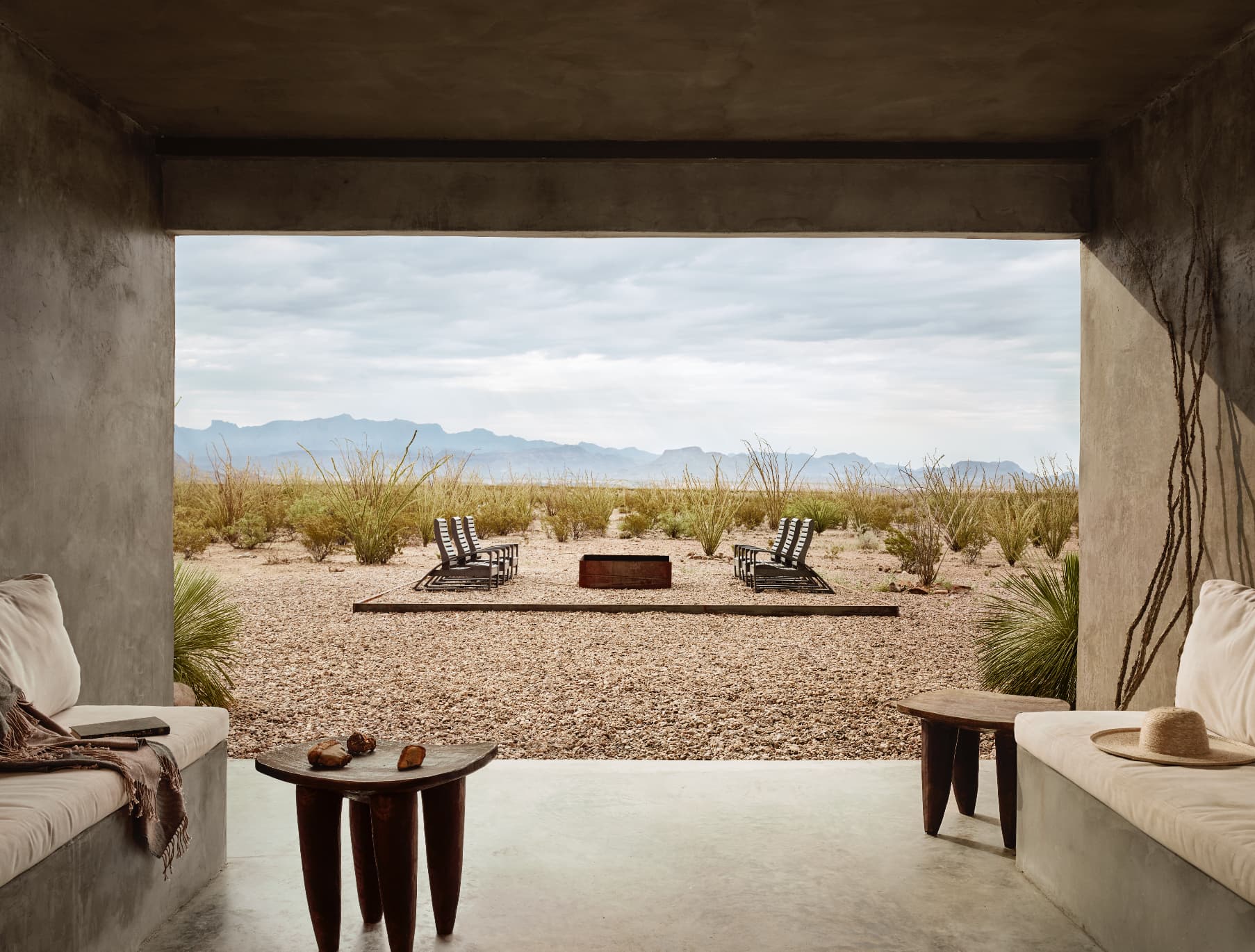 Concrete patio overlooking the West Texas desert with loungers and a fire pit