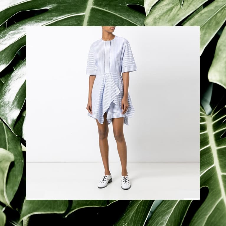 JW Anderson blue striped asymmetric dress framed by monstera leaves