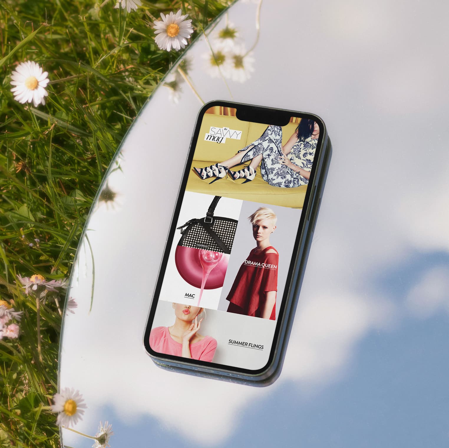 Nordstrom mobile homepage on iPhone laid on mirror reflecting clouds, showing Savvy Mag editorial with Drama Queen and Mac modules