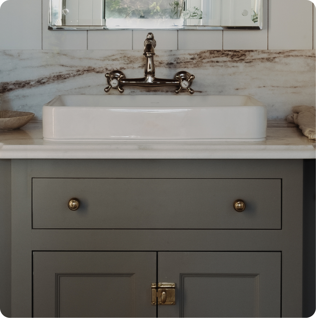Vanity detail, vessel sink with bridge faucet, dramatically veined marble slab