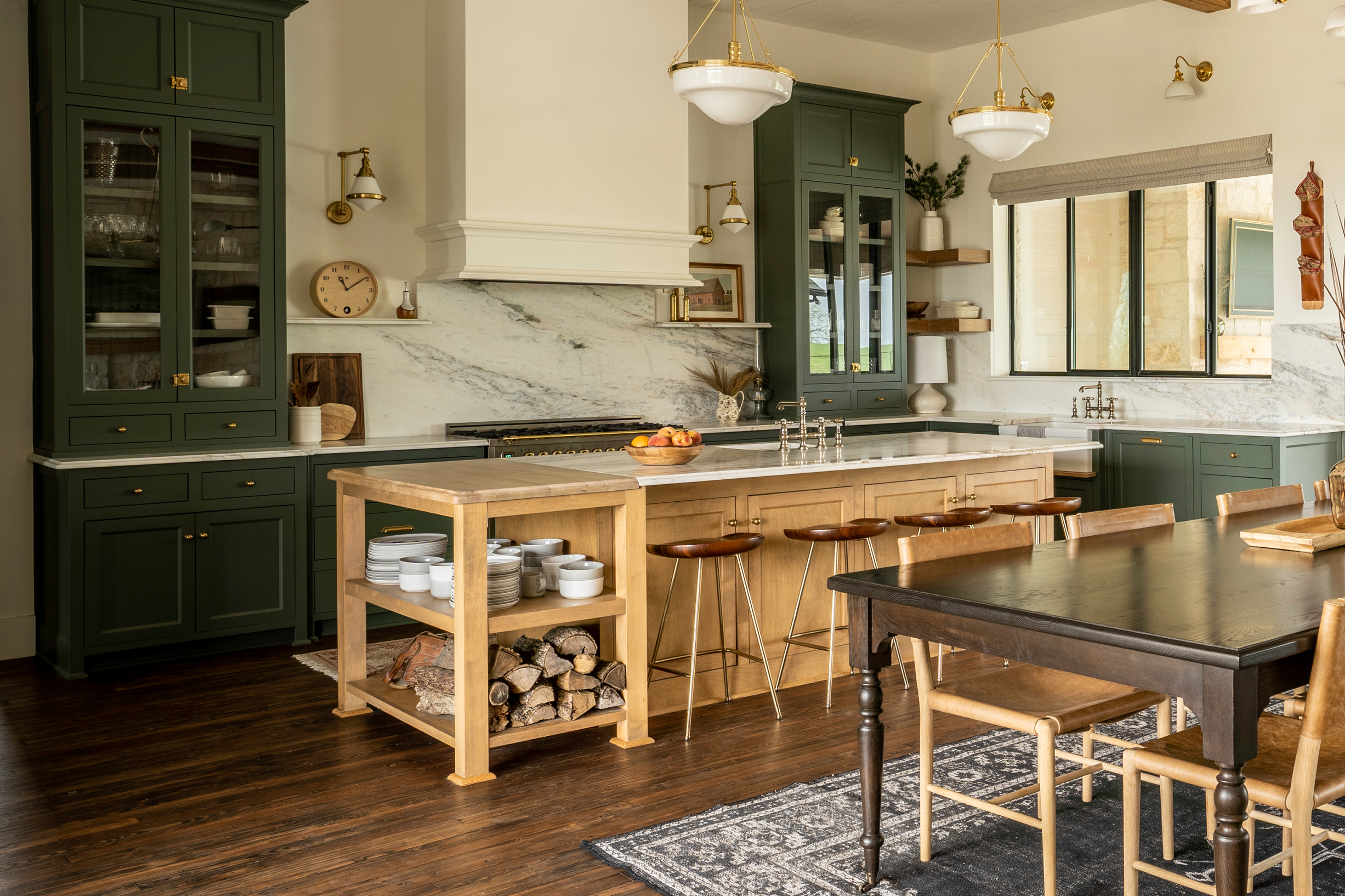 Full kitchen view with dining table, island, sage green cabinetry, steel-frame windows