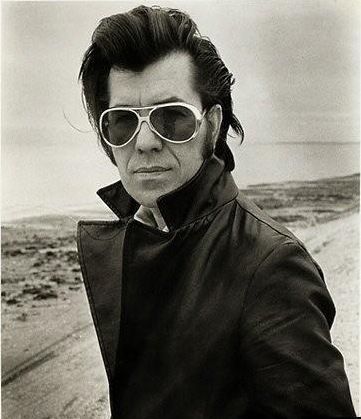 Black-and-white portrait, man in aviator sunglasses and leather jacket at the beach