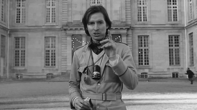 Black-and-white shot of Wes Anderson with camera in a Paris courtyard
