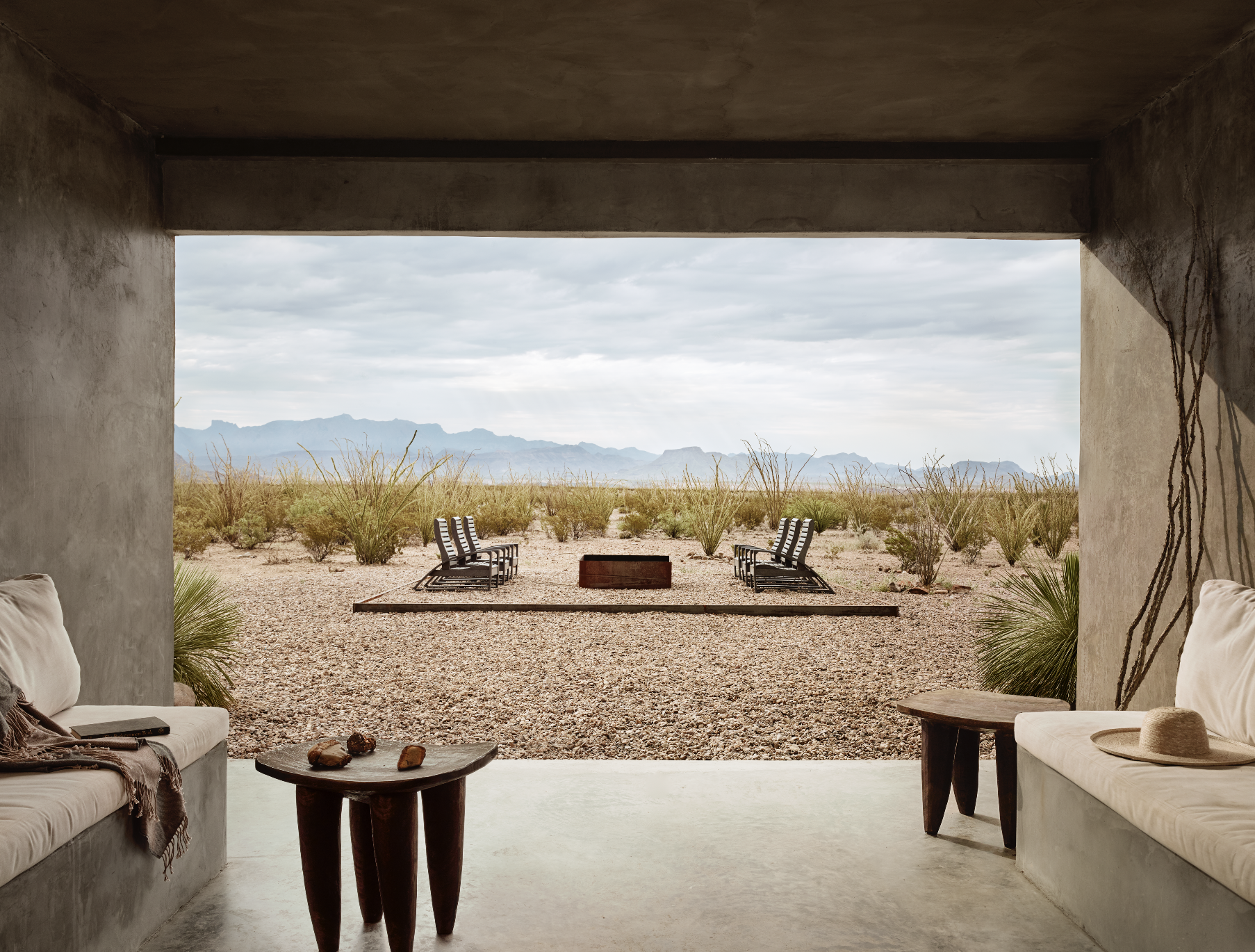 Concrete patio overlooking the West Texas desert with loungers and a fire pit