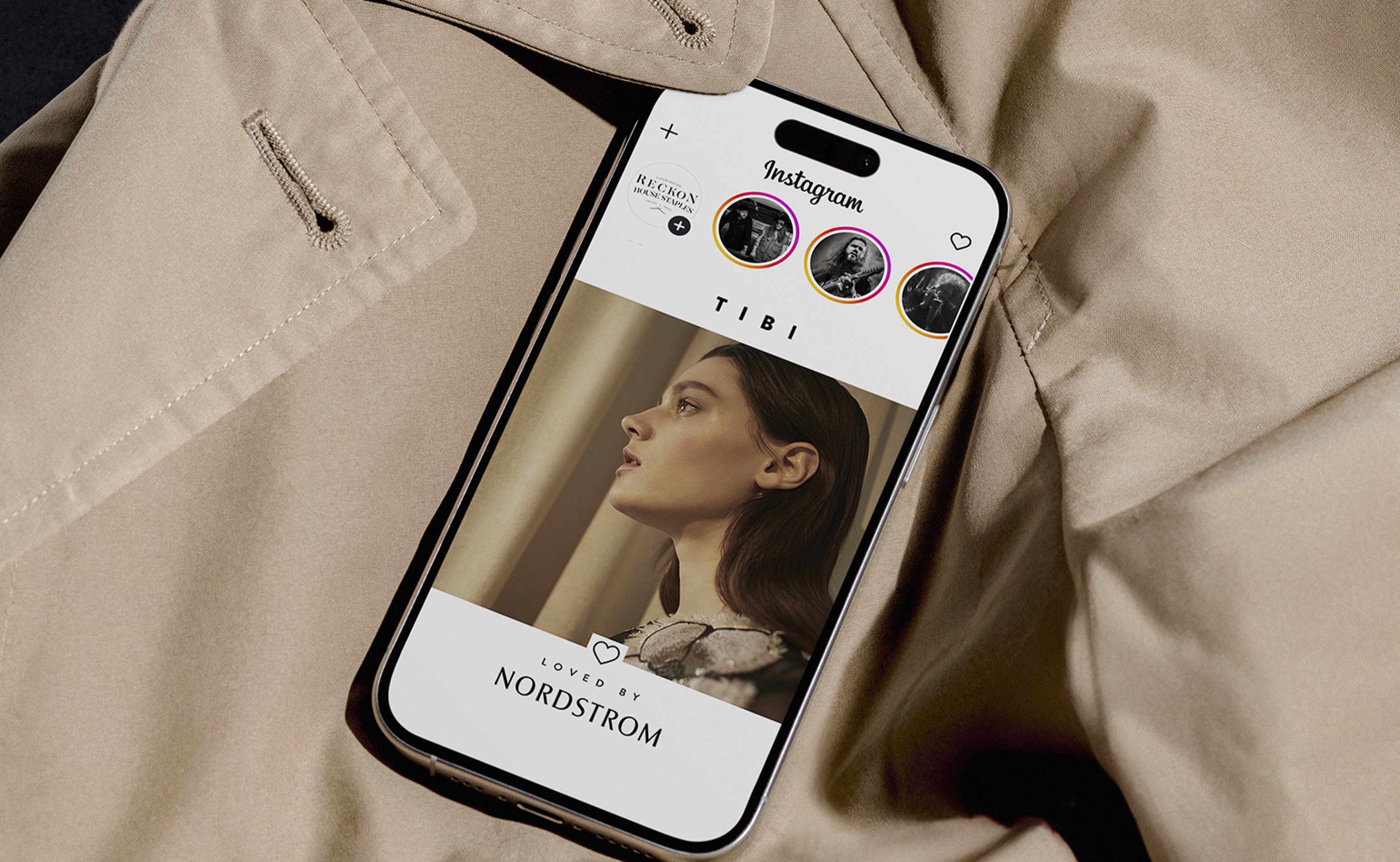 iPhone showing TIBI Loved by Nordstrom story on Instagram laid on a beige trench coat